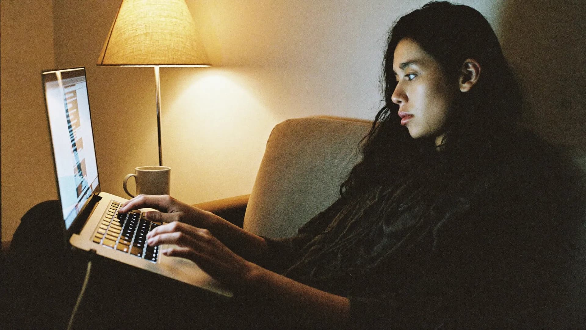 A guest on her laptop by lamplight, late in the evening