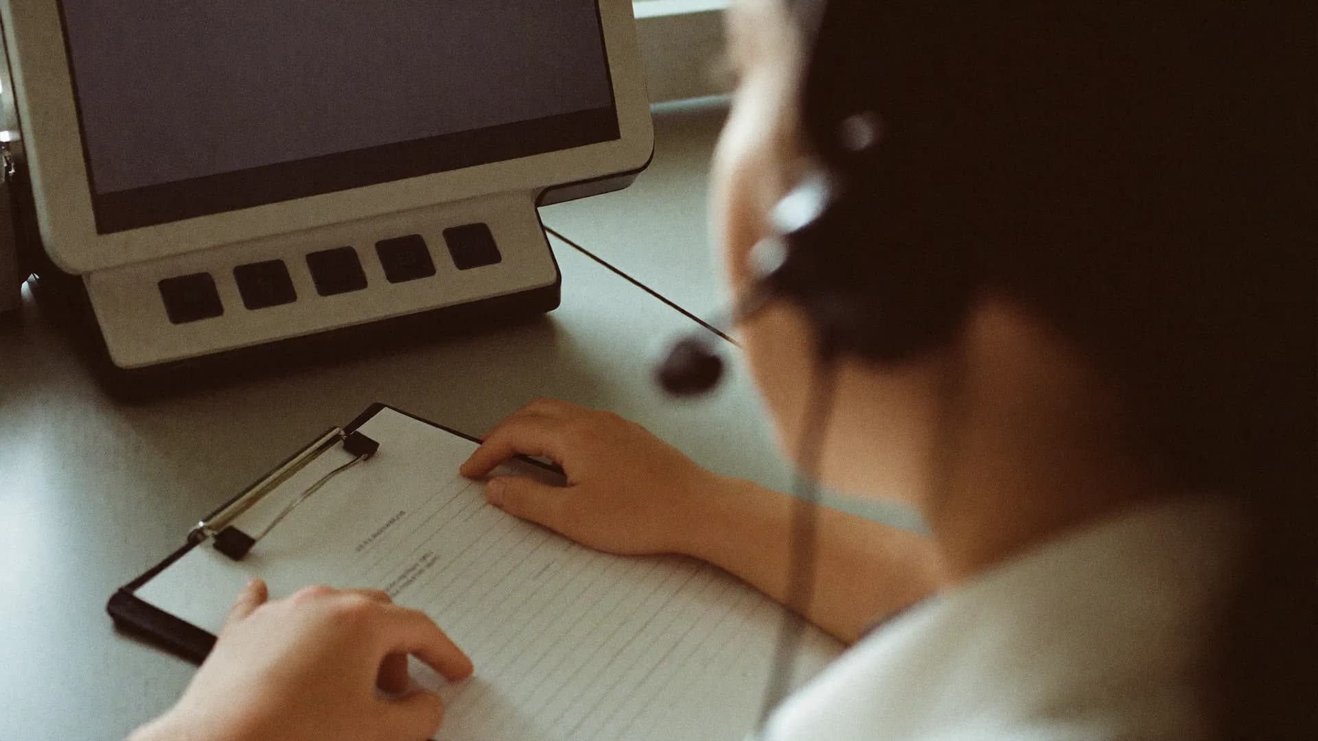 Hands on a patient's intake form at a practice's front desk